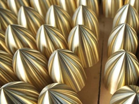The image shows precision-manufactured copper spun components with polished surface finish, demonstrating high repeatability and surface consistency in batch production.